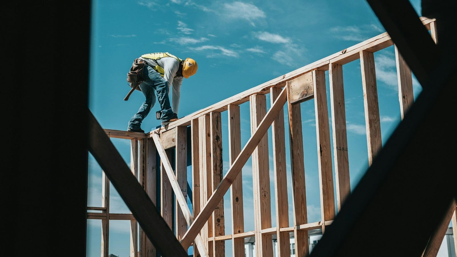 Framer walking the top plate of a wood-framed wall