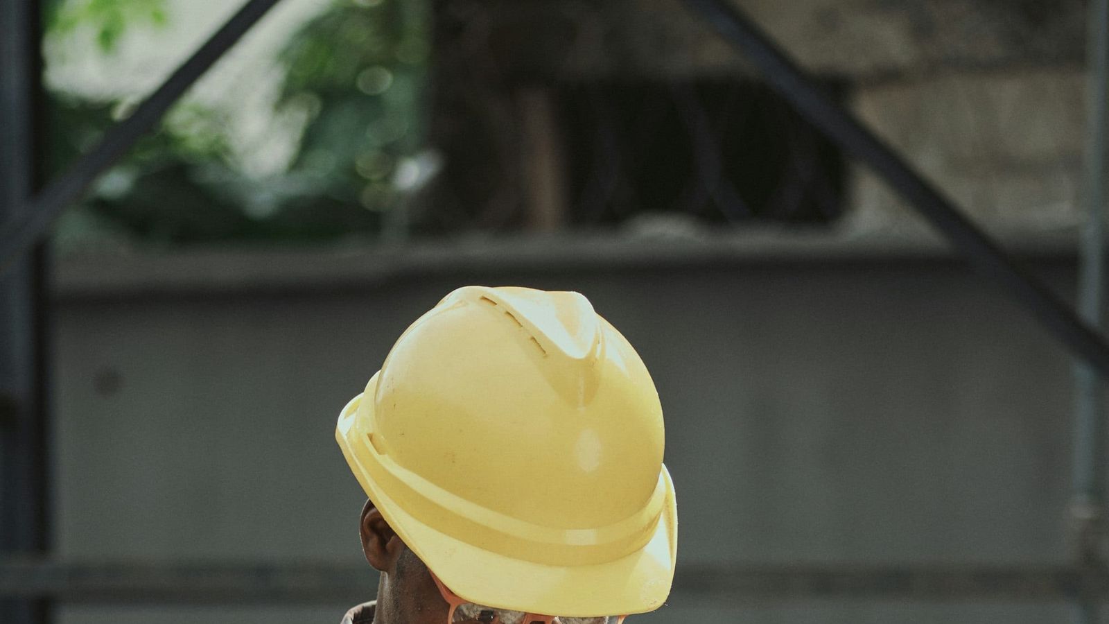 Tradesperson in a hard hat checking a phone on site